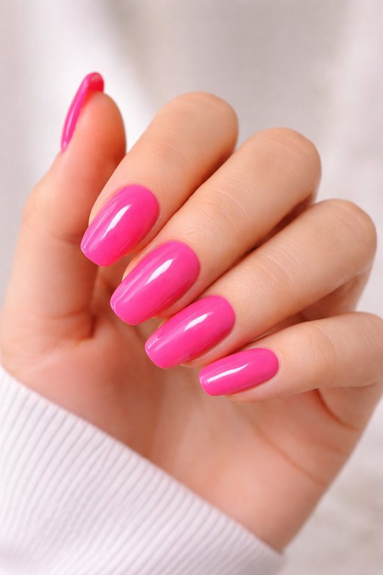 Close-up van een hand met felroze, ovale plaknagels. Zachte glans, korte nagels.