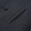 Donkergrijs wollen jas detail met een borstzak en knoop.