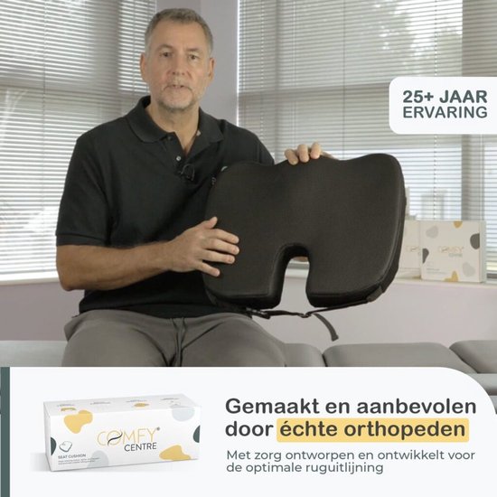 Een man houdt een zwart orthopedisch zitkussen van traagschuim omhoog, met de verpakking.