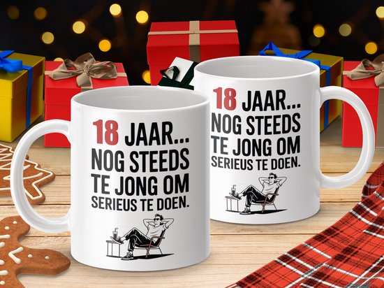 Twee witte mokken met tekst "18 JAAR... NOG STEEDS TE JONG OM SERIEUS TE DOEN." en illustratie van een relaxte man.
