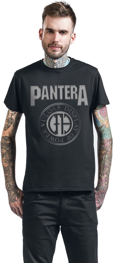 Man met tatoeages draagt een zwart Pantera T-shirt met "VULGAR DISPLAY OF POWER" logo.