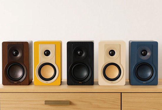 Vijf DALI speakers in verschillende kleuren op een houten meubel.