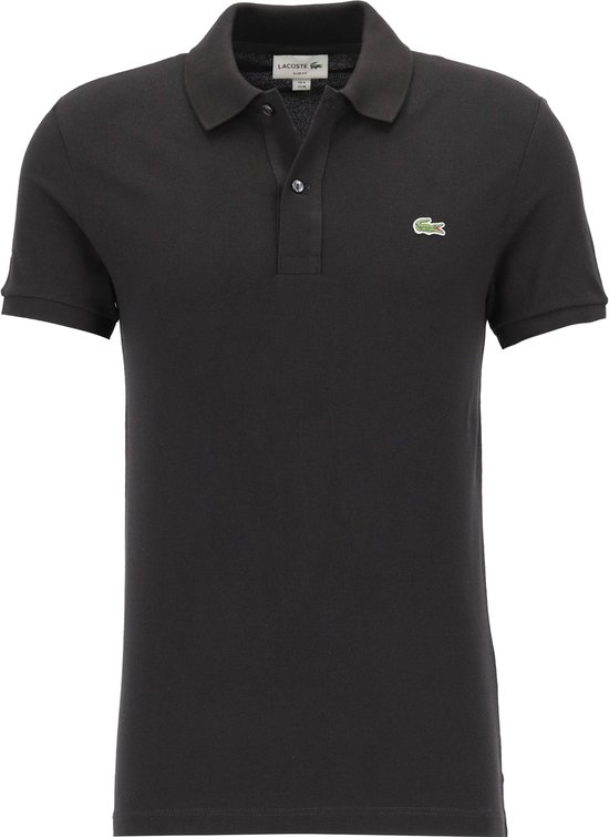 Man die een effen zwart poloshirt met korte mouwen en een groen krokodillenlogo draagt.