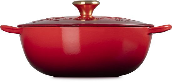 Kersenrode gietijzeren pan met reliëf, deksel met goudkleurige knop.