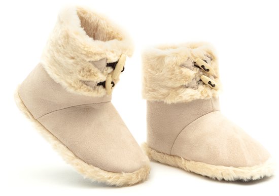 Beige laarsachtige pantoffels met bontrand en houten knopen, op een witte achtergrond.