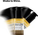 Flesje L'Oréal Absolut Repair Molecular Oil in beweging met vaag water.