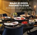 Gourmetstel in gebruik met vlees, vis en groenten, omringd door bijgerechten op een gedekte tafel.