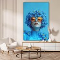 Portrait bleu d'une femme avec des lunettes orange et des fleurs, dans un salon.