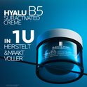 Blauwe pot met witte deksel. La Roche-Posay Hyalu B5 Crème Suractivée. Tekst: 'In 1 uur herstelt & maakt voller'.