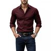 Homme portant une chemise bordeaux, un jean foncé, une ceinture en cuir et une montre, mains dans les poches.