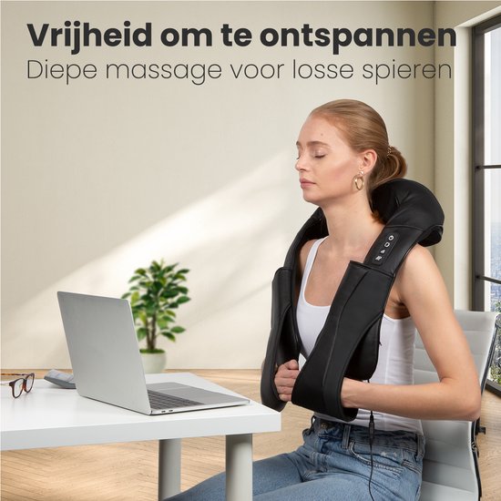 Vrouw gebruikt het zwarte nek- en schoudermassageapparaat zittend aan een bureau met laptop.