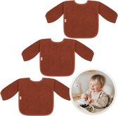 Drie koperkleurige slabbetjes met lange mouwen, gemaakt van badstof. Elk slabbetje heeft een roodbruine rand en een roze label.