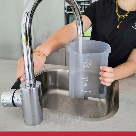 Een persoon vult het Senseo-reservoir met water onder een kraan.