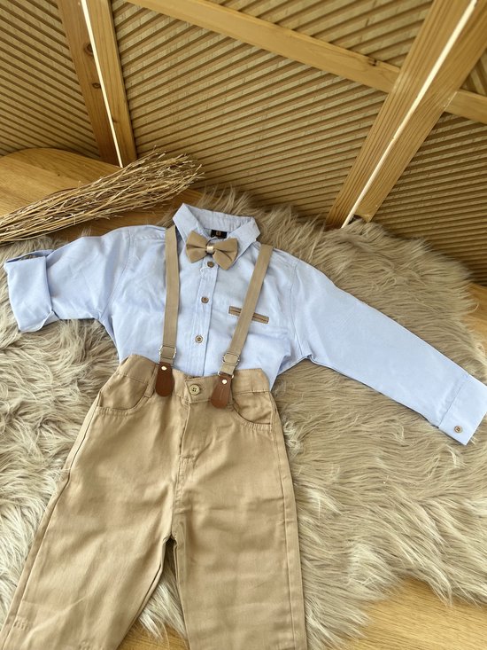 Lichtblauw overhemd met beige vlinderdas en bretels, gecombineerd met beige broek.