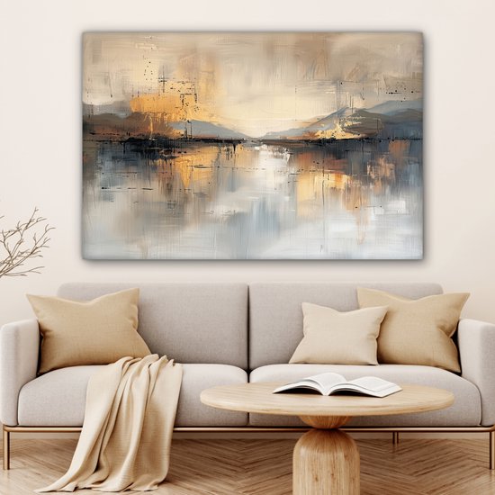 Abstract schilderij met gouden, beige, grijze en zwarte tinten, hangend boven een bank met kussens en een salontafel.