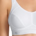 Detailopname van een witte sportbeha met naden en logo.