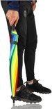Een man met sportbroek houdt een gesloten regenboogparaplu vast. De paraplu is in elkaar gevouwen met veelkleurige vlakken.