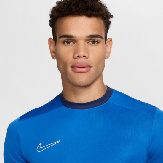 Close-up van een blauw sportshirt met witte Nike 'swoosh'.