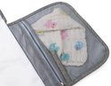 Detail van een gaasvak met babykleertjes op de grijze verschoonmat.