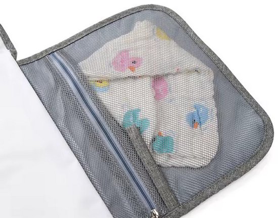 Detail van een gaasvak met babykleertjes op de grijze verschoonmat.