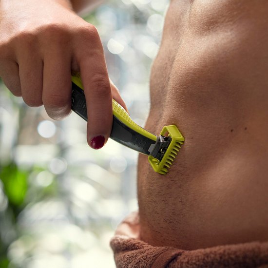 Hand gebruikt gele en zwarte OneBlade trimmer op de huid onder de nek.