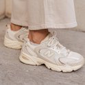 New Balance 530 sneakers in beige, gedragen met crème broek.