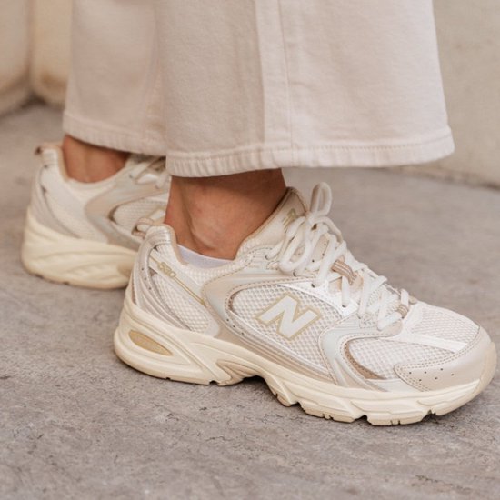 New Balance 530 sneakers in beige, gedragen met crème broek.