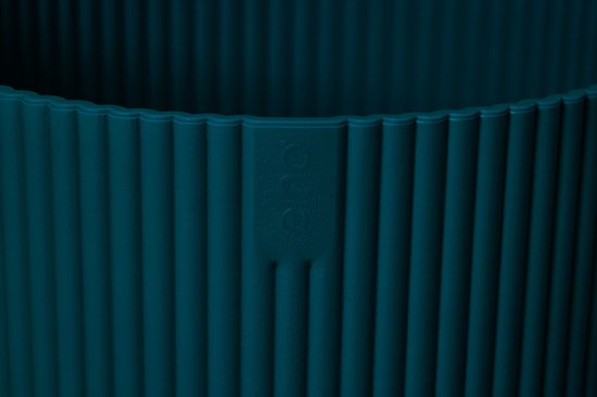 Detail van de bovenrand van een diepblauwe bloempot met verticale ribbels en een subtiel Elho logo.