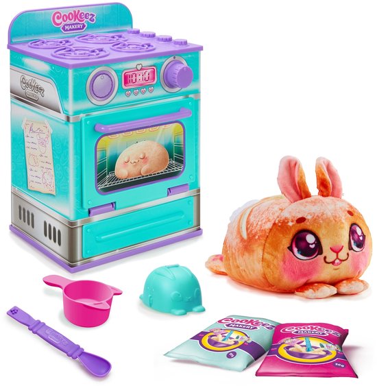 Paars-turquoise oven met een bruine pluche donut erin, naast een paars-turquoise oven. Op de tafel liggen een pluche konijn, een lepel, een maatbeker en twee zakjes.