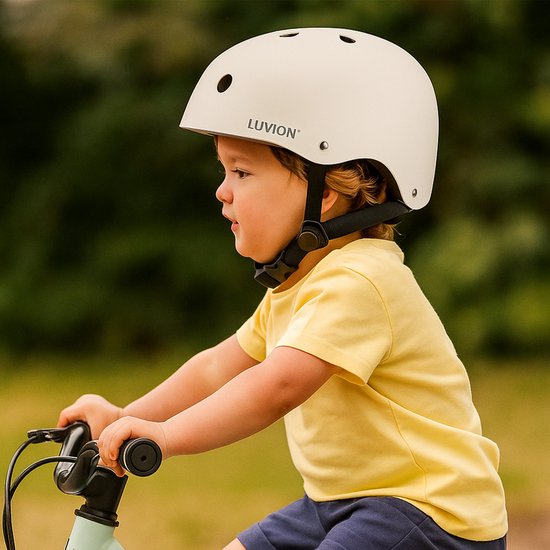 Jongetje in een zandkleurige helm met het LUVION® logo, op een fiets.
