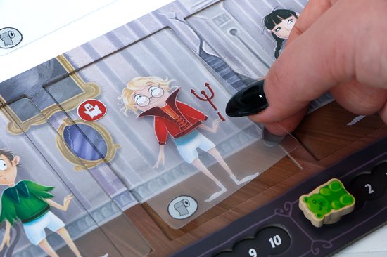 Vinger die een lucifer van een jongen in pyjama plaatst in het bordspel Tricky Treats.