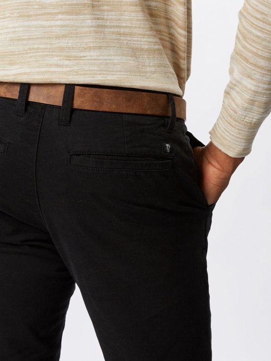 Close-up van de achterkant van een zwarte chino broek met bruine riem.