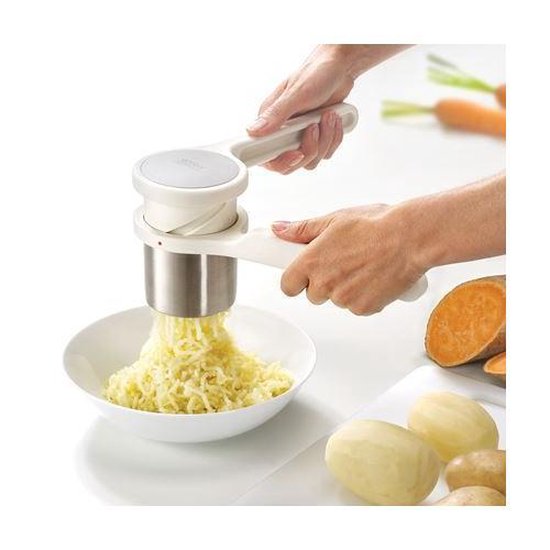 Witte Helix aardappelpers in gebruik, die aardappelen tot slierten perst in een witte kom.