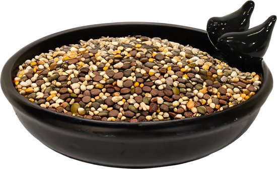 Zwarte keramische vogelvoederschaal met twee zwarte keramieken vogeltjes, gevuld met een mix van vogelzaad.