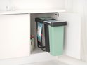 Mintgroene en donkergrijze Brabantia prullenbakken, in elkaar geschoven in een keukenkastje.
