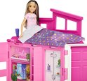 Barbie pop in roze speelhuis met bed.
