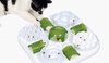 Wit Catit Senses 2.0 Food Maze met groene deksels, een zwart-witte kat pakt eten.
