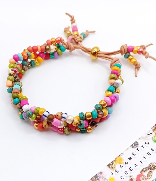 Gekleurde kralenarmband met bruine leren koordjes en gouden details. Inclusief 'JEANNETTE CREATIEF' tekst.
