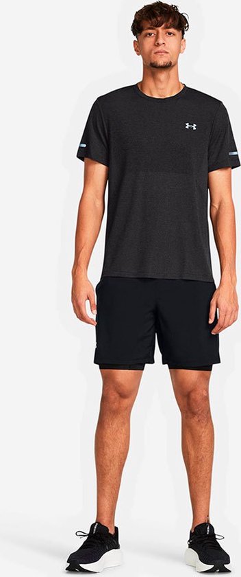 Man in een zwarte sportbroek en donkergrijs sportshirt met reflecterende details op de mouwen.