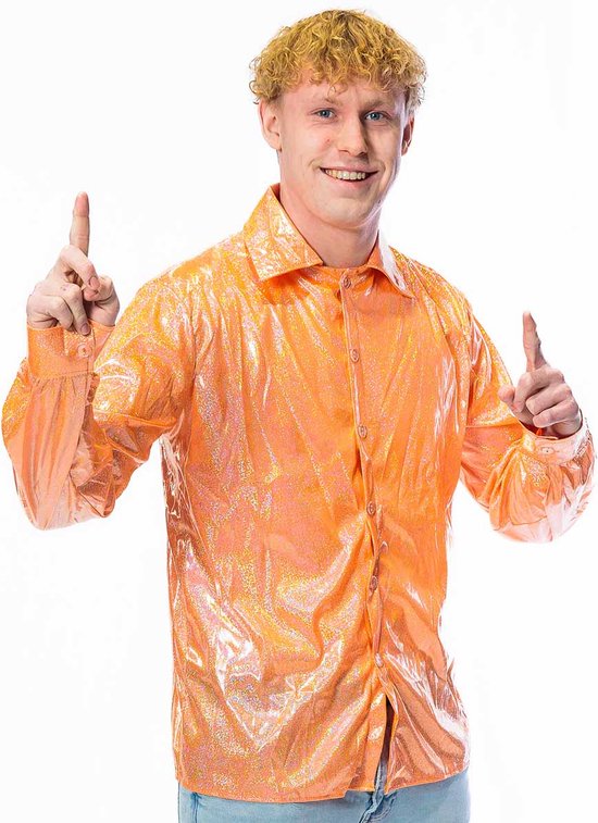Homme aux cheveux blonds bouclés porte une chemise orange à paillettes et un jean clair, pouces levés.
