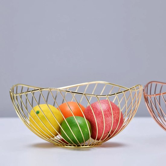 Gouden fruitschaal met verticale spijlen, gevuld met een gele citroen, sinaasappel, groene limoen en rode appel.