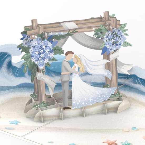 Close-up van pop-up kaart met bruidspaar op een zandstrand onder een houten boog met blauwe bloemen en golven.