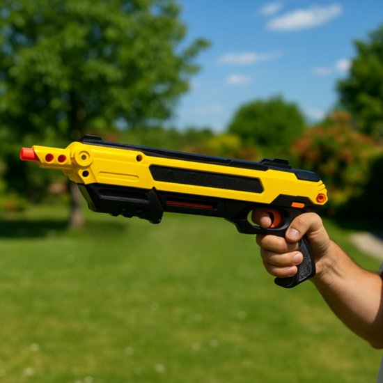 Hand met een gele en zwarte 'Salt Power Gun' in de tuin.