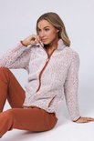 Vrouw in een lichtroze teddy fleece trui met bruine rits en broek.