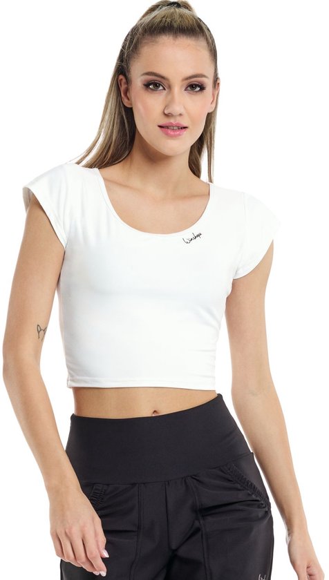 Model in witte crop top met korte mouwen en zwarte sportbroek.