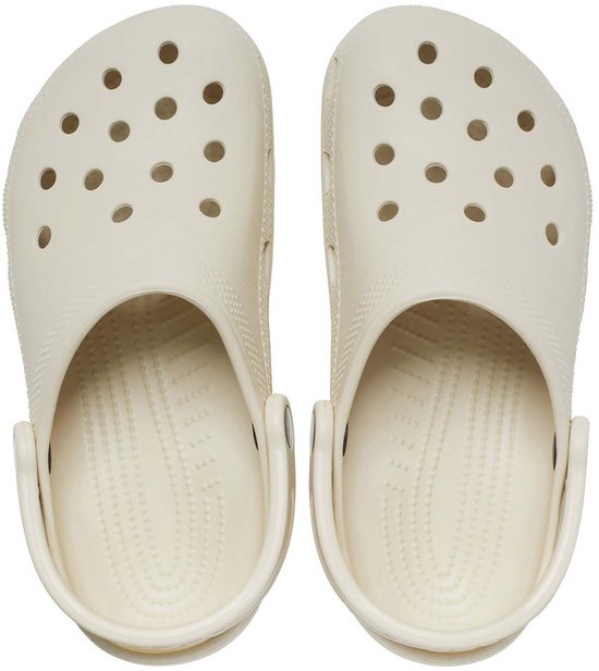 Paar lichtgele Crocs Classic klompen, van bovenaf gezien, met perforaties.