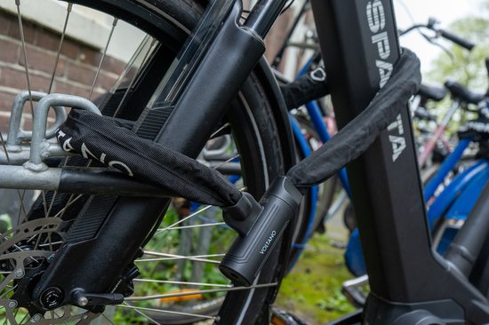 Zwart Voltano kettingslot met nylon hoes, beveiligd rond een fietsframe.