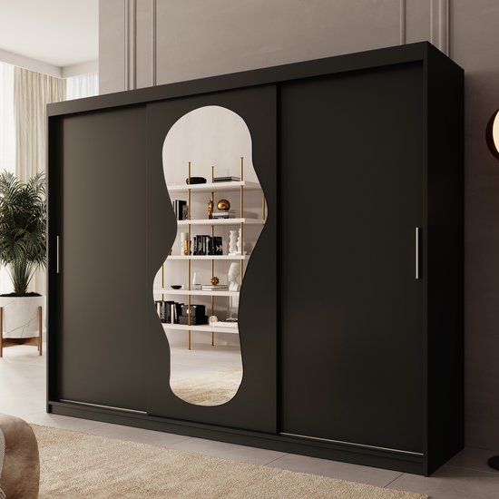 Zwarte kledingkast met schuifdeuren en een organische spiegel die een open kast met boeken en decoratie weerspiegelt.
