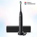 Zwarte Philips Sonicare elektrische tandenborstel met oplader, reisdoos en 'Made in the Netherlands' icoon.