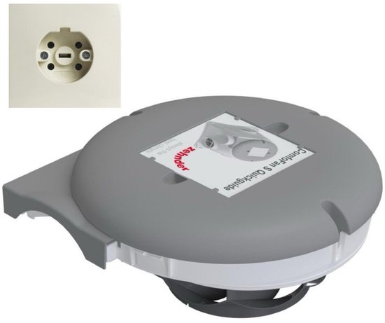 Grijze ComfoFan S Quickguide ventilator met witte rand en papieren handleiding, naast een crème kleurig perilex stopcontact.